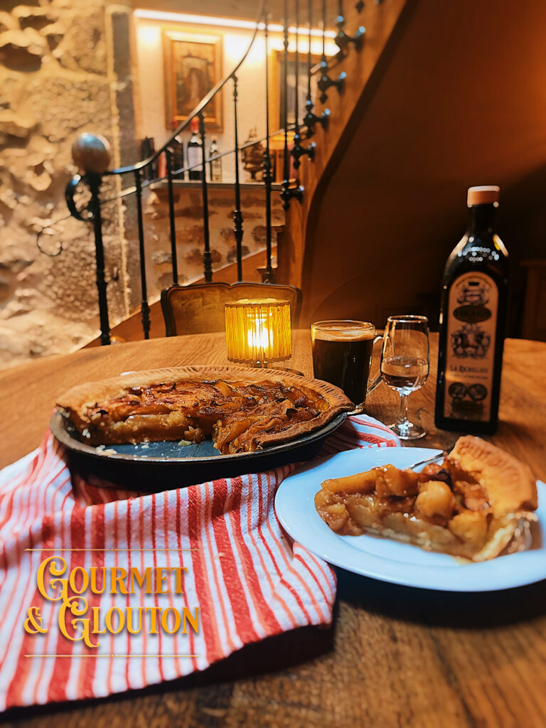 Tarte aux pommes maison à pâte épaisse et beurrée, signée Cécile chez Gourmet & Glouton à Chaudes-Aigues, servie tiède avec un café de dégustation.