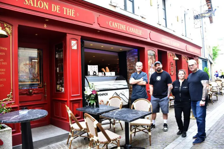 Façade du restaurant Gourmet & Glouton à Chaudes-Aigues, inspiré des brasseries parisiennes, avec équipe devant le restaurant et l’atelier de tatouage
