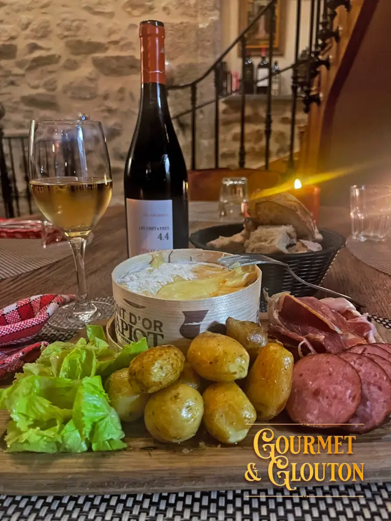 Mont d’Or chaud dans sa boîte, accompagné de pommes de terre, de charcuterie et de salade chez Gourmet & Glouton à Chaudes-Aigues.