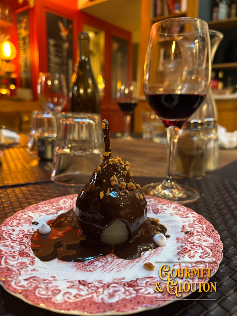 Poire Belle-Hélène servie au restaurant Gourmet & Glouton à Chaudes-Aigues, dessert traditionnel composé de poire pochée, sauce chocolat et chantilly maison.