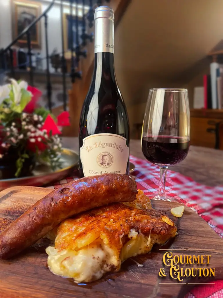 Gros plan sur la saucisse à l’ancienne dorée, servie avec pommes sautées et persil à Chaudes-Aigues