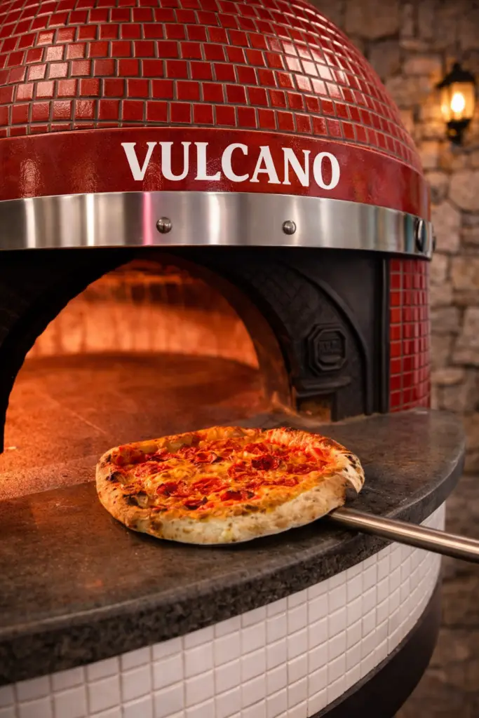 Pizza cuite au feu de bois dans un four Vulcano à Chaudes-Aigues, style trattoria artisanale