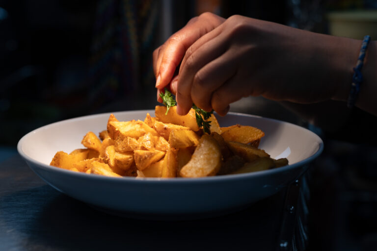 Frites maison dorées servies dans une assiette blanche au restaurant Gourmet & Glouton