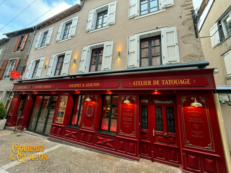 Façade en pierre avec volets rouges à Chaudes-Aigues, détail architectural de la Maison Chaudesaigues.