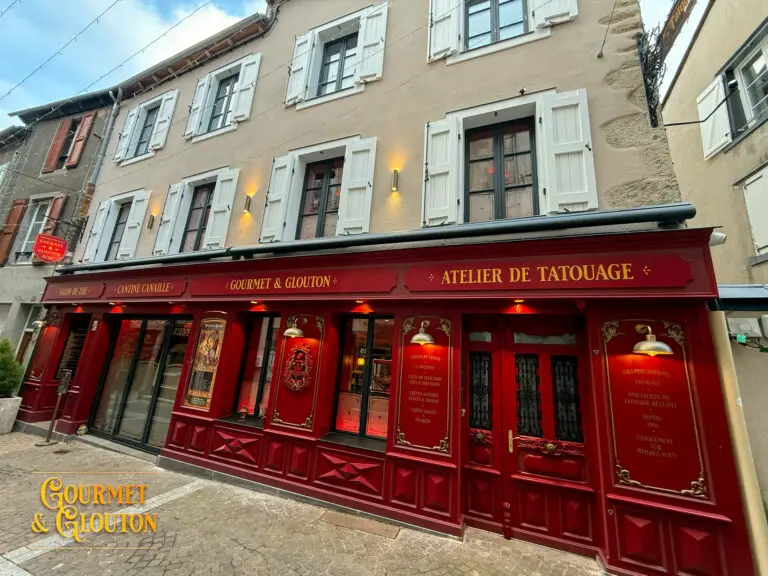 Façade en pierre avec volets rouges à Chaudes-Aigues, détail architectural de la Maison Chaudesaigues.