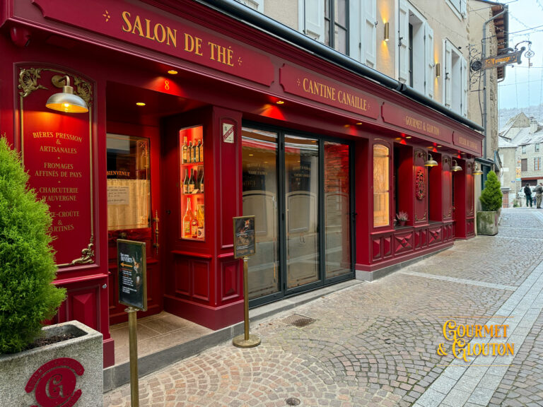 Façade en pierre avec volets rouges à Chaudes-Aigues, détail architectural de la Maison Chaudesaigues.