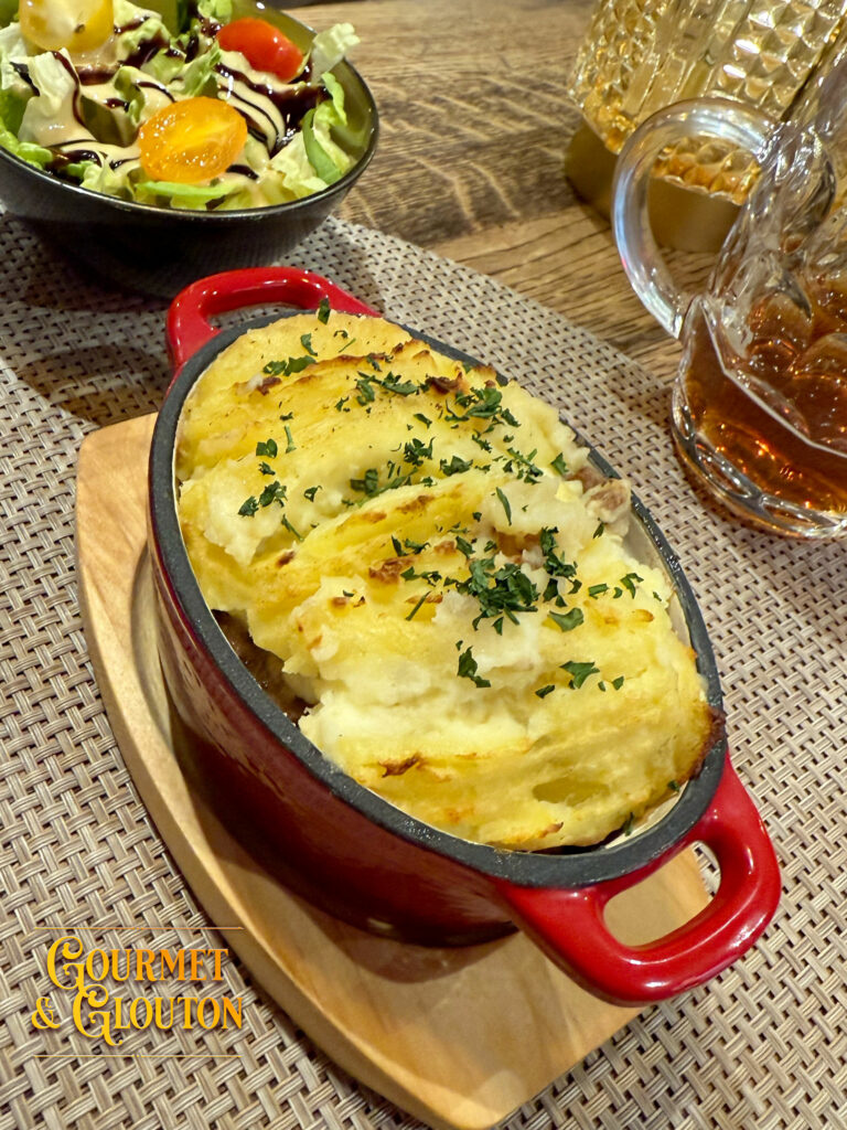 Gros plan sur le hachis Parmentier maison du restaurant Gourmet & Glouton, avec viande 100 % Aubrac sous une purée maison gratinée.