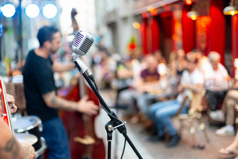 Micro vintage installé en terrasse lors d’un concert estival chez Gourmet & Glouton à Chaudes-Aigues, devant un public réuni pour une soirée musicale conviviale.