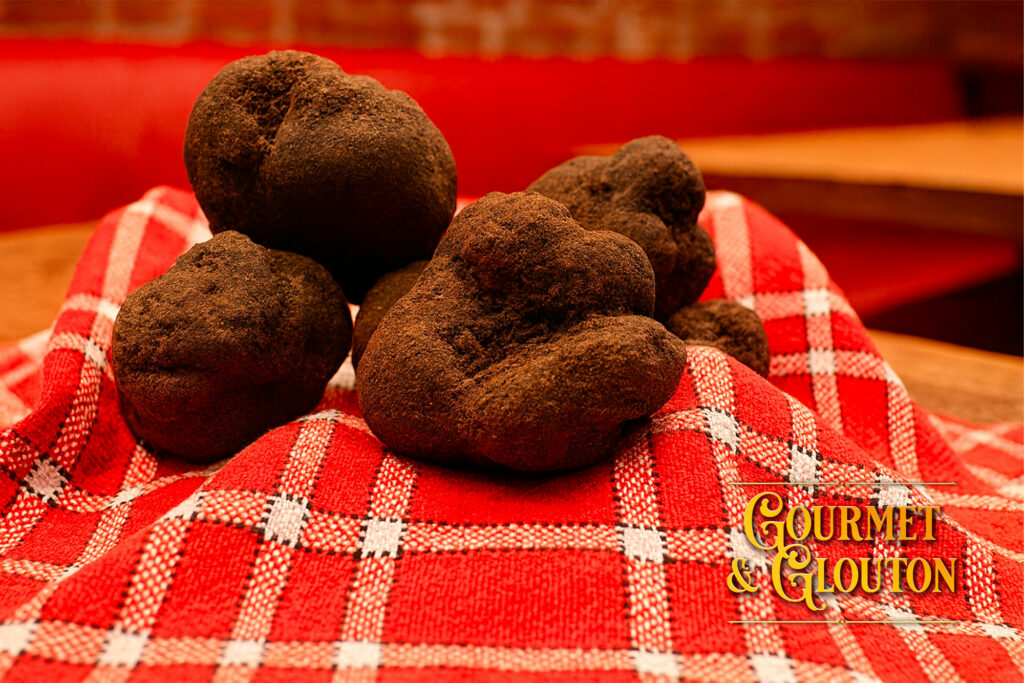 Truffes noires fraîches présentées sur un linge de bistrot au restaurant Gourmet & Glouton à Chaudes-Aigues