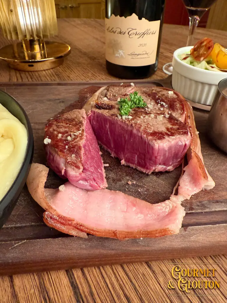 Pièce de viande Aubrac servie avec vin Clos des Truffiers au restaurant Gourmet & Glouton