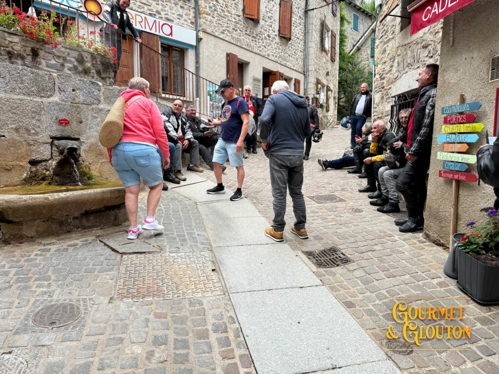 Habitants et visiteurs rassemblés autour de la Source du Par à Chaudes-Aigues avant l'arrivée de Loïc Ballet pour le tournage d'un reportage.