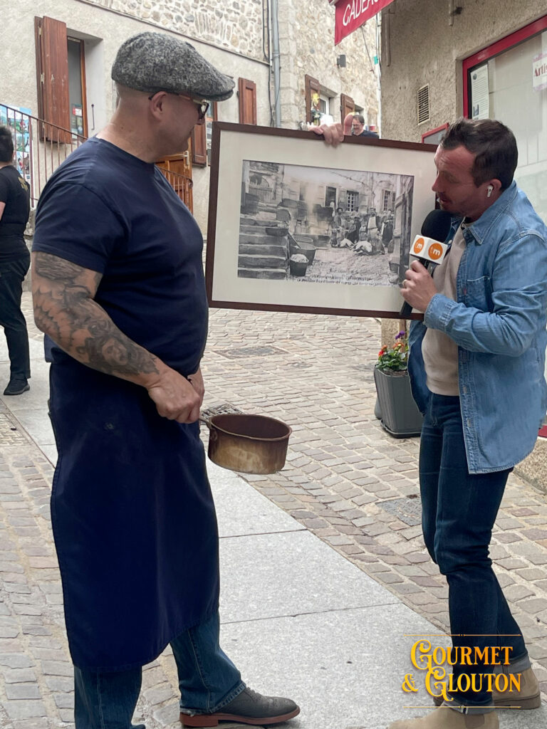 Stéphane Chaudesaigues présente à Loïc Ballet une archive historique montrant les bouchers utilisant l'eau chaude de la Source du Par à Chaudes-Aigues.