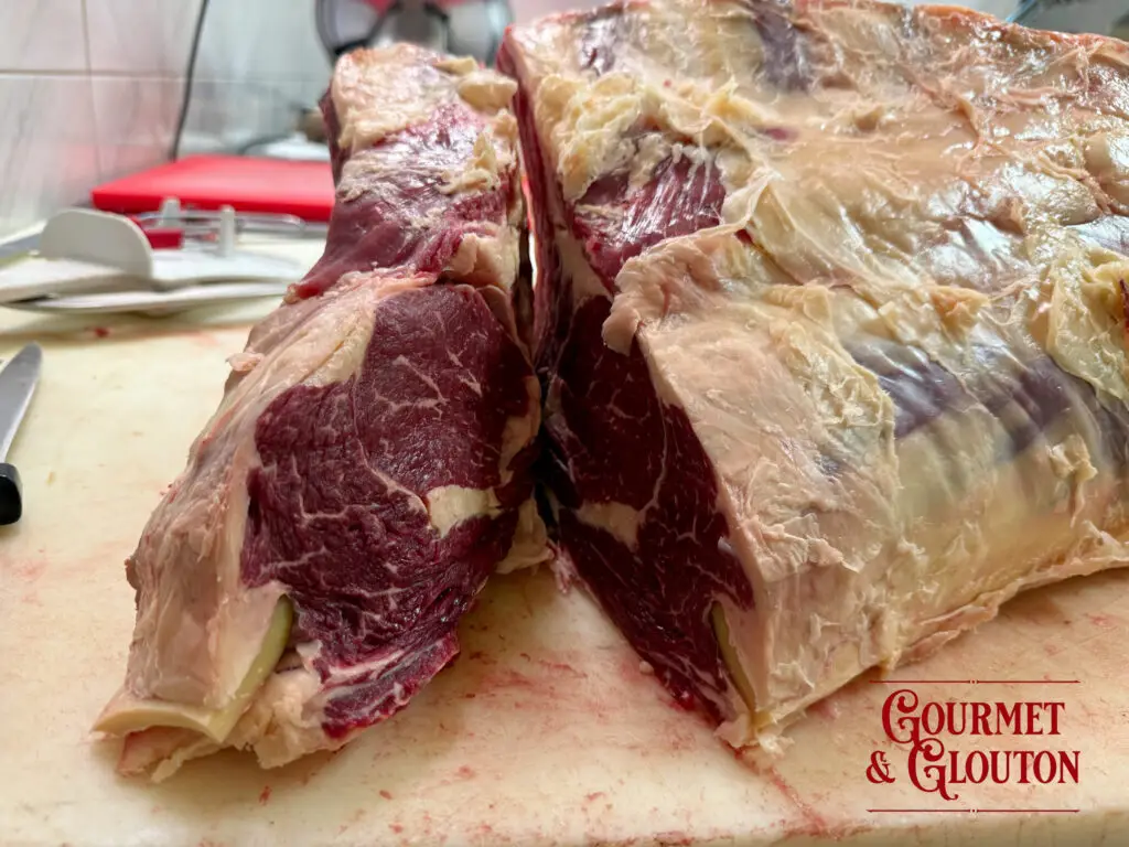 Carcasse de Black Angus française avant découpe chez Gourmet & Glouton à Chaudes-Aigues, mettant en évidence le persillage naturel et la qualité de cette viande d'exception.