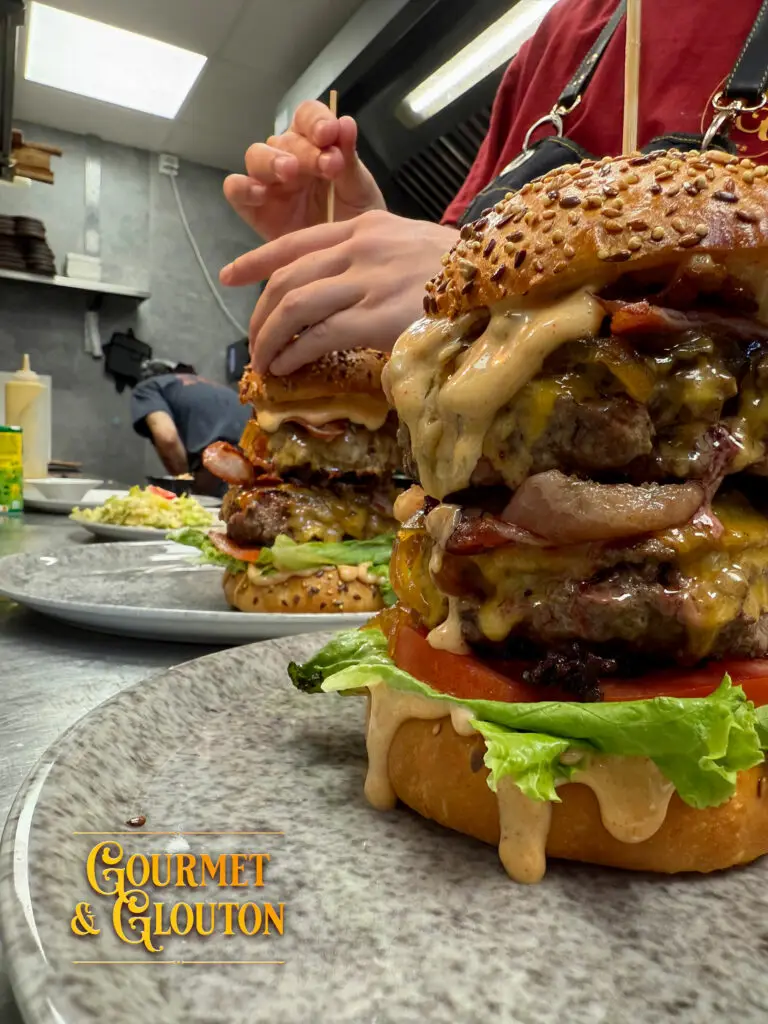 Préparation du Titan en cuisine chez Gourmet & Glouton à Chaudes-Aigues, burger réalisé sur demande avec jusqu'à 400 g de viande hachée 100 % pur muscle Aubrac.