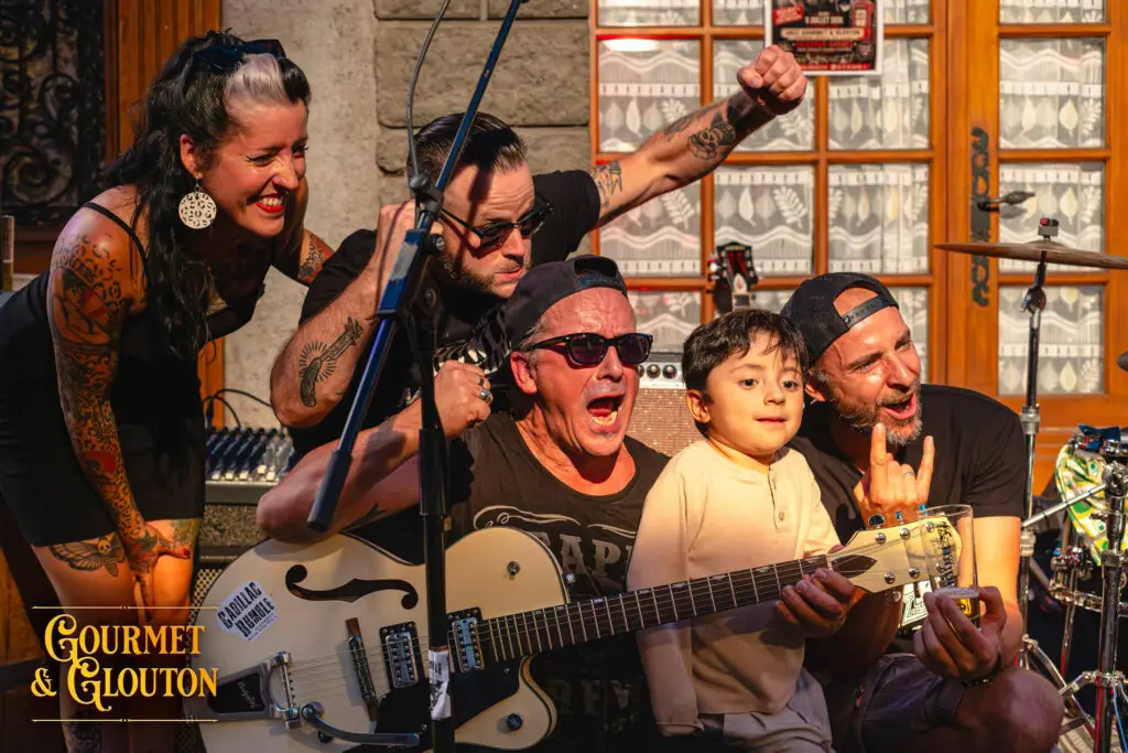 Benjamin pose avec Cadillac Rumble pendant les Terrasses Musicales 2026 chez Gourmet & Glouton, dans un moment de transmission rock’n’roll à Chaudes-Aigues.