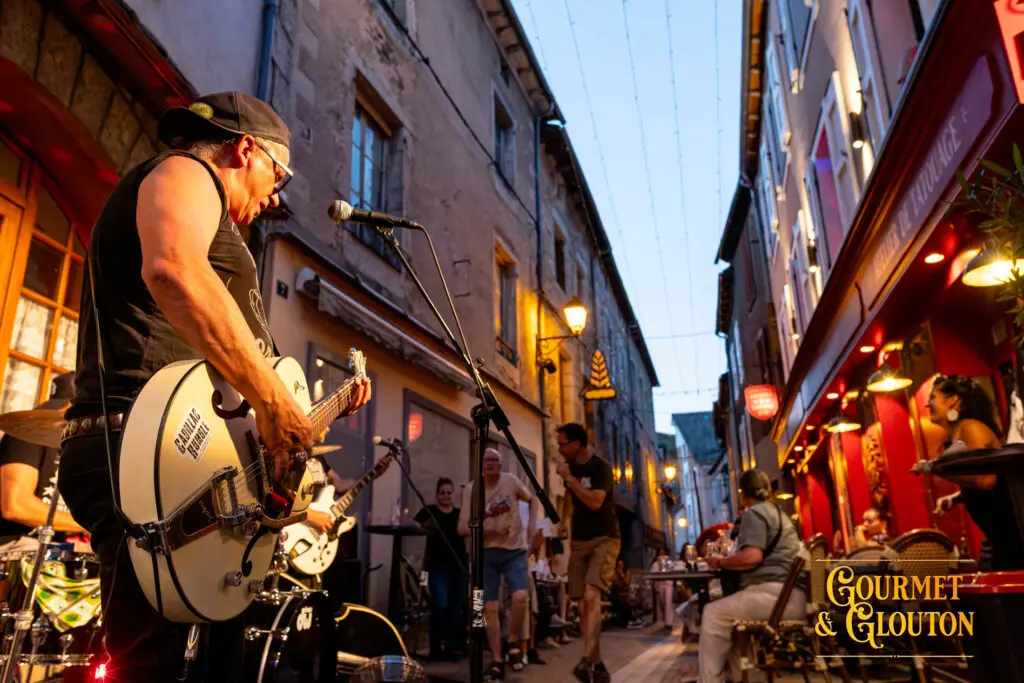 Guitariste de Cadillac Rumble en concert dans la rue Notre-Dame d’Août pendant les Terrasses Musicales 2026 chez Gourmet & Glouton à Chaudes-Aigues.