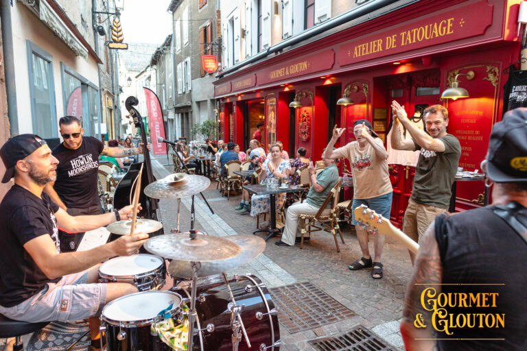 Cadillac Rumble joue devant le public sur la terrasse de Gourmet & Glouton, rue Notre-Dame d’Août, pendant les Terrasses Musicales 2026 à Chaudes-Aigues.