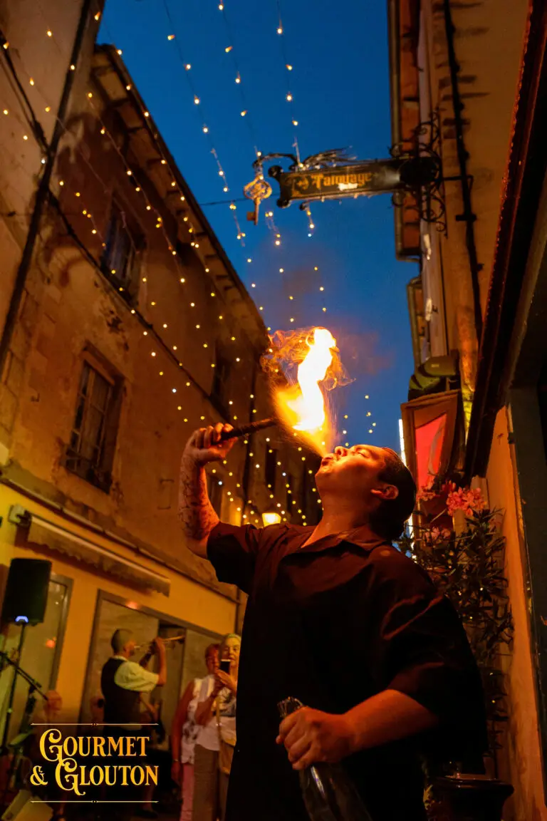 Enzo Petit Dragon crache du feu dans la rue Notre-Dame d’Août lors des Terrasses Musicales de Chaudes-Aigues.