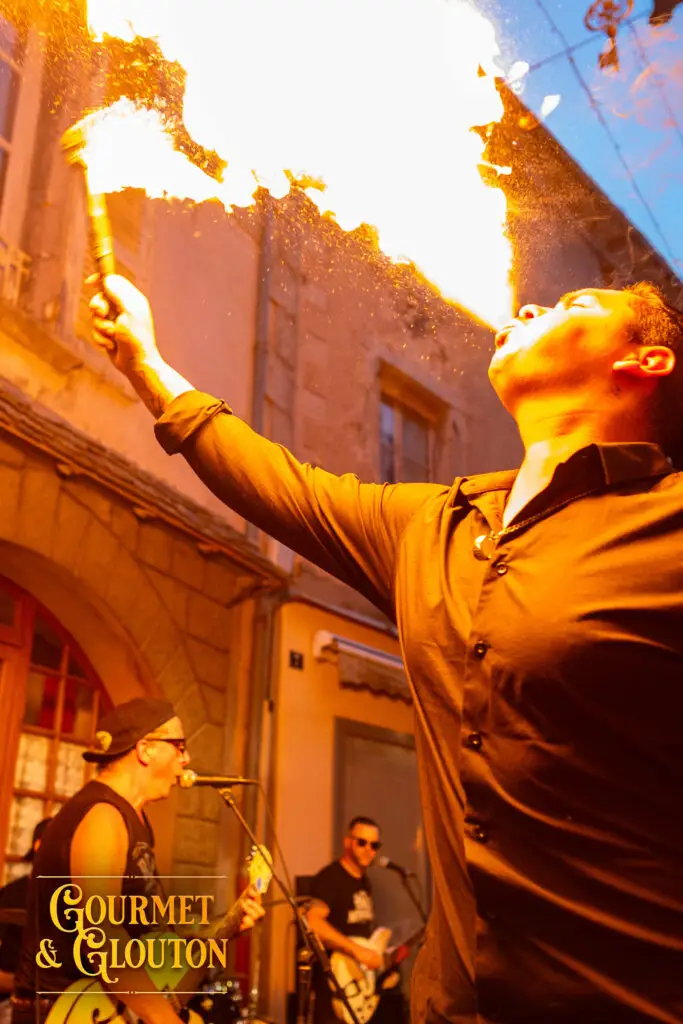 Enzo, alias Petit Dragon, capitaine de cuisine de Gourmet & Glouton, crache le feu pendant le concert de Cadillac Rumble à Chaudes-Aigues.