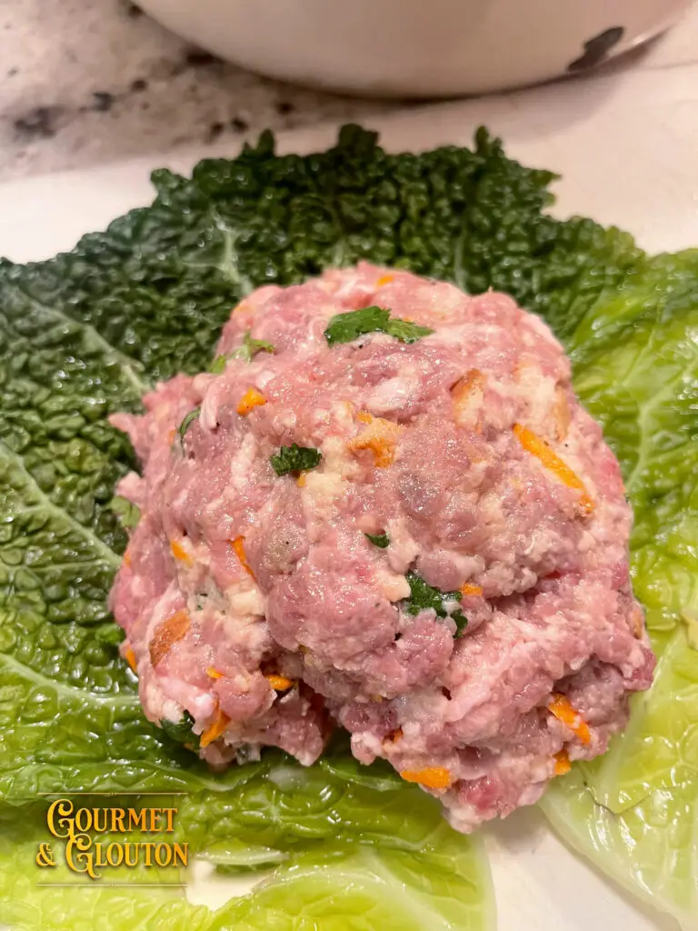Farce maison à la viande, aux carottes et aux herbes déposée sur une feuille de chou chez Gourmet & Glouton