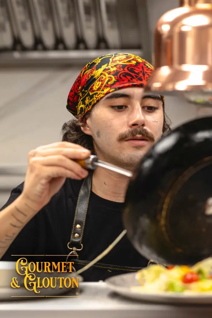 Cuisinier de Gourmet & Glouton concentré en plein service, dans l’esprit d’une brigade de cuisine façon équipage de pirates à Chaudes-Aigues.