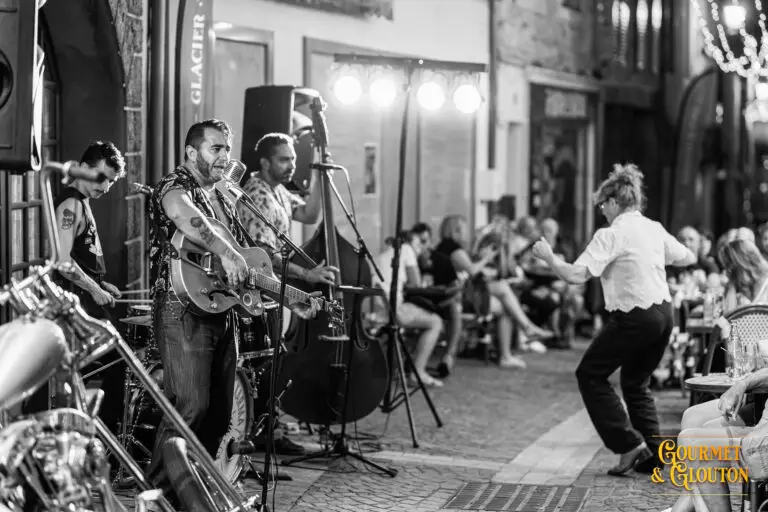 Wild Karma en concert pendant qu’une spectatrice danse aux Terrasses Musicales de Chaudes-Aigues.