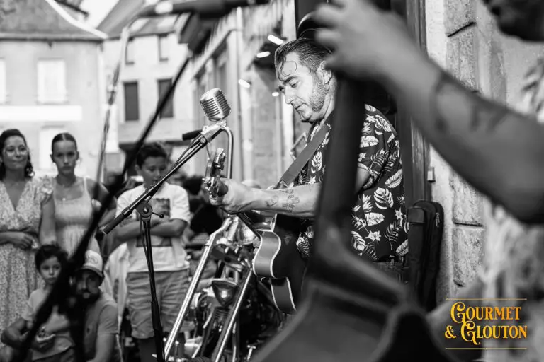 Guitariste de Wild Karma en concert devant le public dans la rue Notre-Dame d’Août à Chaudes-Aigues.